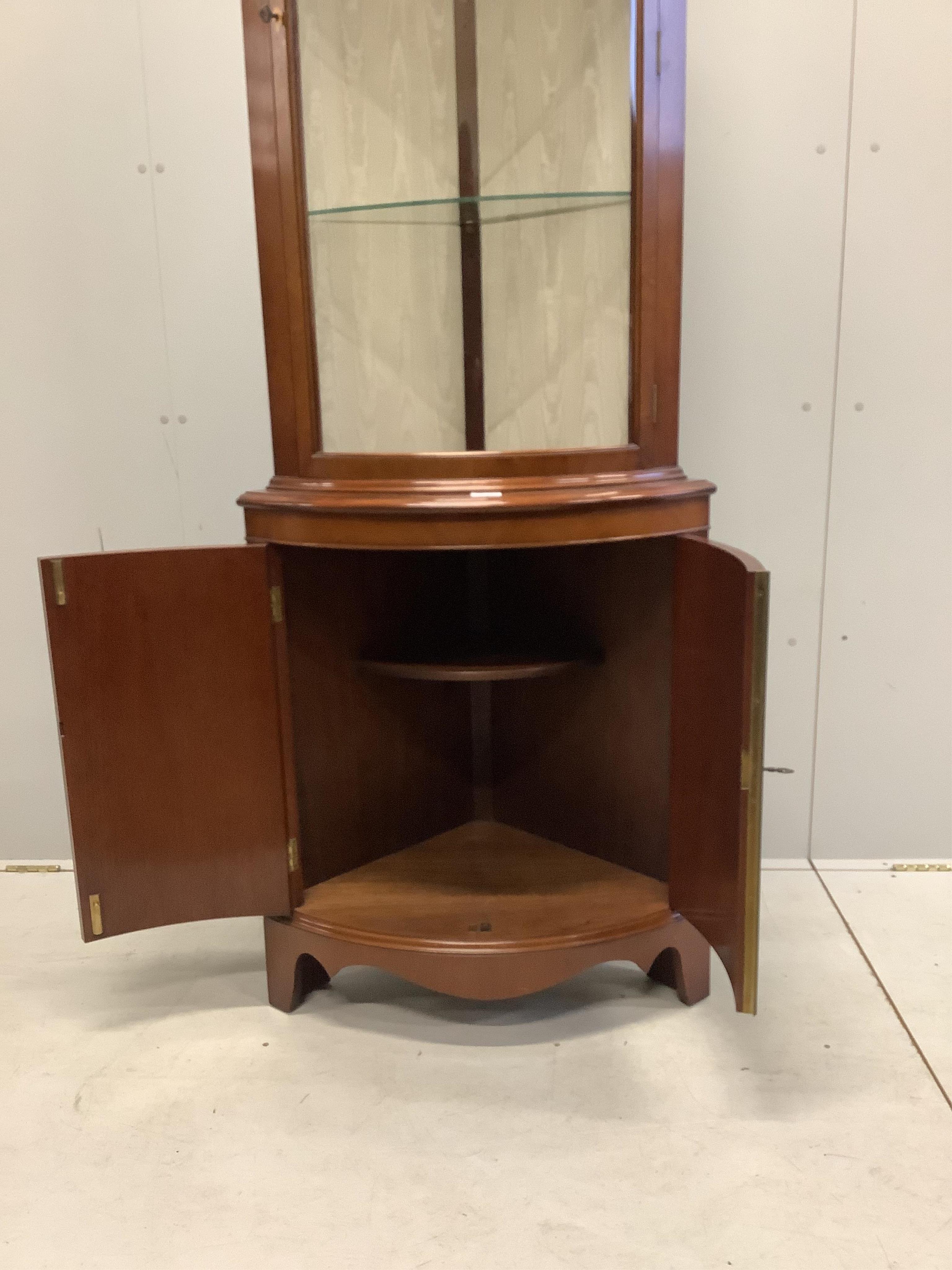 A reproduction Sheraton style inlaid mahogany bow fronted standing corner cupboard, width 70cm, depth 46cm, height 203cm. Condition - good